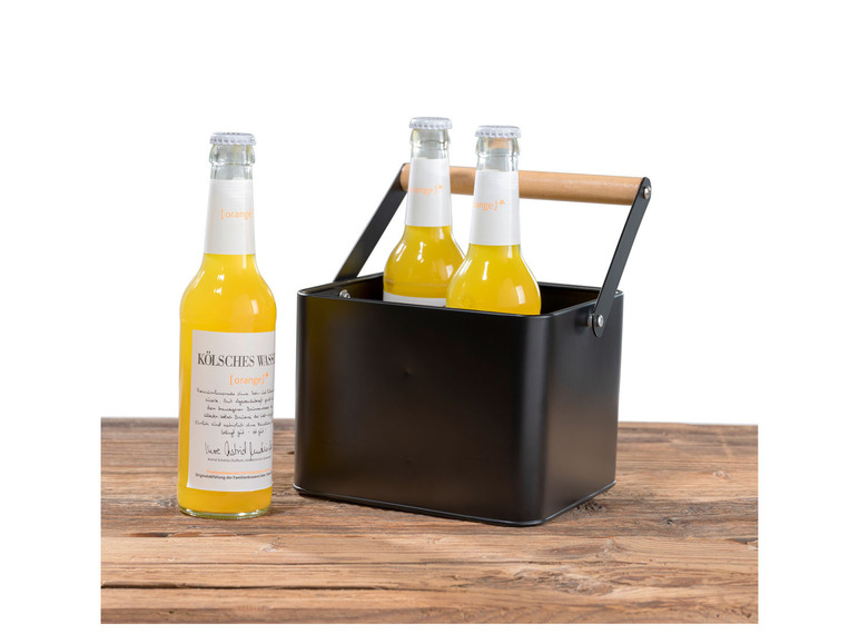 Trois bouteilles de limonade à l'orange dans un seau noir avec une poignée en bois.