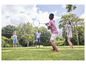 Une famille joue au badminton dans le jardin.