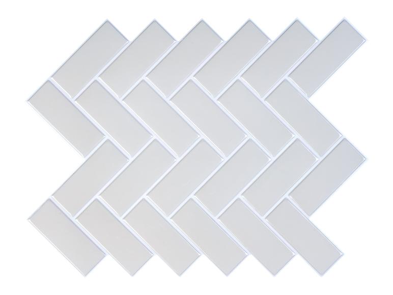 Carreaux adhésifs blancs en forme de chevrons pour crédence de cuisine ou salle de bain.