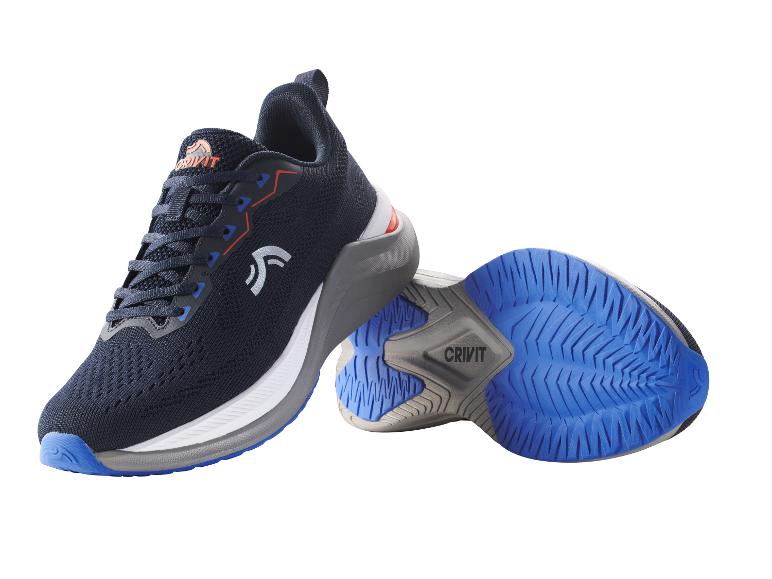Paire de chaussures de sport bleu marine et blanches avec semelles bleues, l'une debout, l'autre sur le côté.