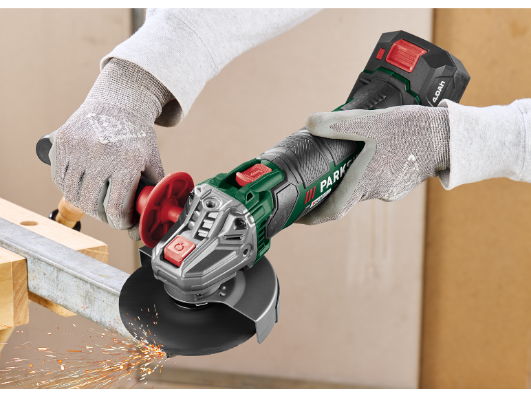 Mains gantées utilisant une meuleuse d'angle pour couper une barre métallique, avec des étincelles.