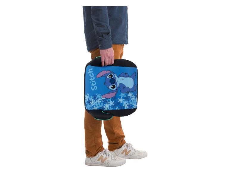 Homme tenant un rehausseur de voiture bleu pour enfant avec motif Stitch.