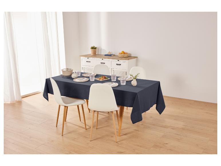 Nappe de table, chaises et vaisselle sur une table à manger.