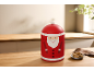 Boîte à biscuits Père Noël sur un comptoir de cuisine en bois avec des biscuits et une plante.
