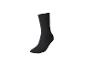 Une chaussette noire, debout sur un fond blanc.