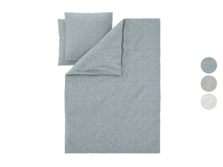 Parure de lit bleu clair à motif floral blanc, avec des échantillons de motifs supplémentaires.