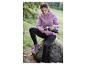 Une femme en sweat-shirt rose à capuche et leggings noirs, boit du thé dans une thermos en pleine nature.