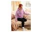 Une femme portant un sweat-shirt rose à l'effigie de Mickey Mouse est assise sur un canapé.