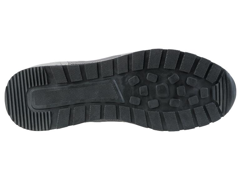 La semelle d'une sneaker grise avec une semelle en caoutchouc.