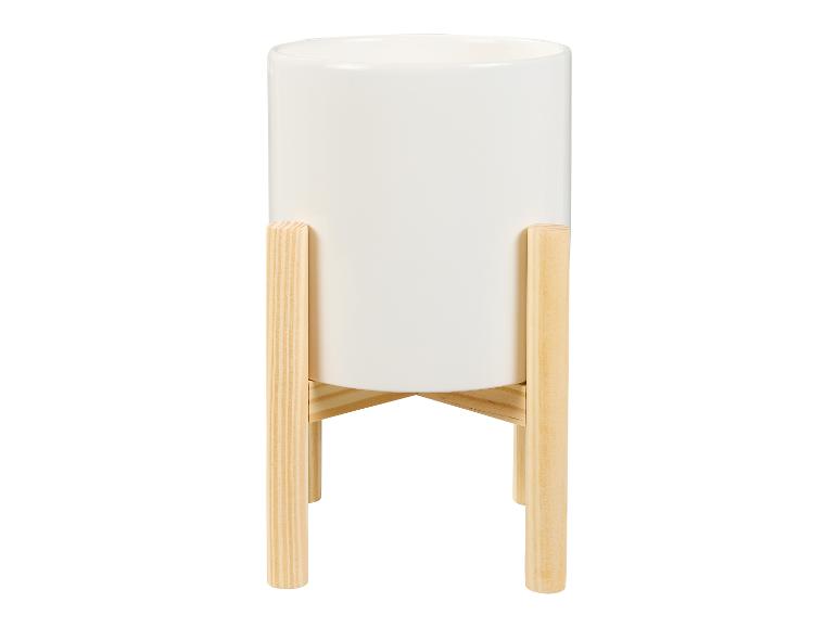 Pot de fleurs blanc sur un support en bois.