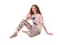 Femme en pyjama rose Mickey Mouse, assise et souriante.