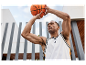 Un homme en maillot de basket-ball lance un ballon.