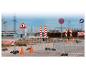 Ensemble de construction avec clôtures, panneaux et cônes.