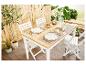 Table et chaises pliantes blanches, vaisselle, et ambiance extérieure zen.