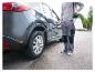 Un homme pulvérise un pneu de voiture avec un pulvérisateur.