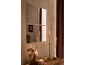 Miroirs et bougies sur une commode en bois, créant une ambiance chaleureuse.