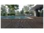Terrasse en bois au bord d'une piscine avec maison moderne et verdure en arrière-plan.