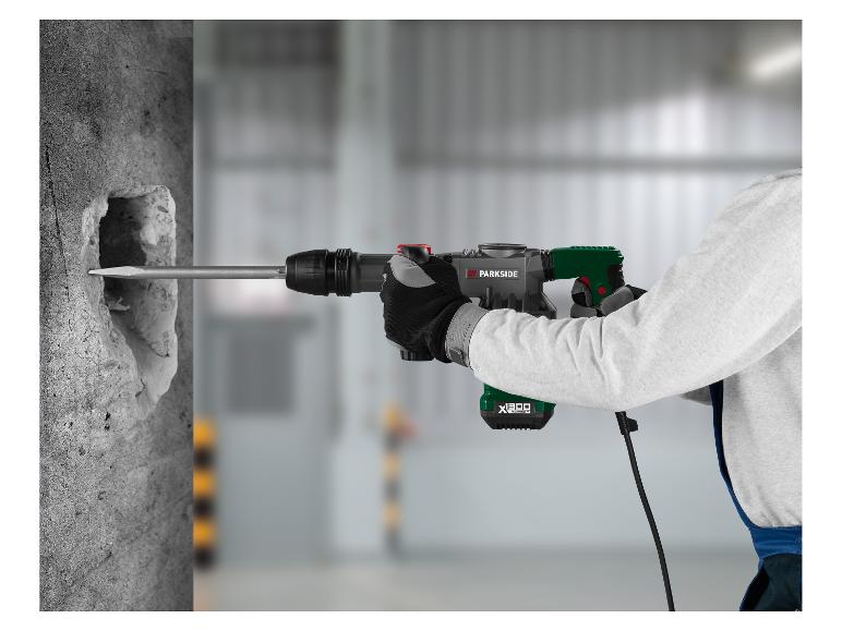 Un ouvrier utilise un marteau perforateur pour percer un trou dans un mur en béton.