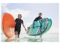 Deux personnes transportent des planches de paddle gonflables Aqua-Marina dans l'eau.