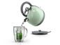 Une bouilloire verte Silvercrest verse de l'eau dans une tasse avec des feuilles de menthe.