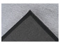 Détail d'un tapis en fourrure gris avec une bordure noire.