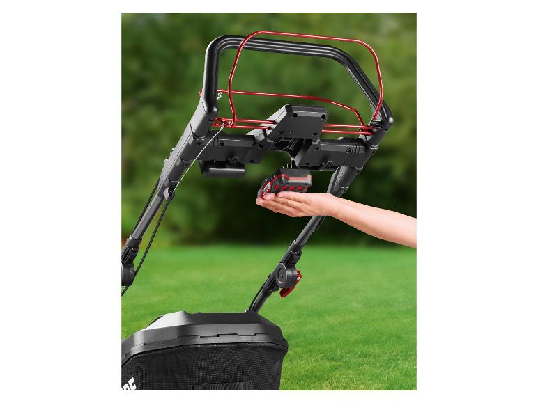 Main insérant une batterie dans une tondeuse à gazon sans fil Parkside.