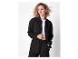 Modèle portant un ensemble pantalon et chemise noirs en coton.