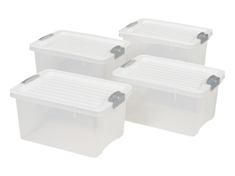 Quatre boîtes de rangement transparentes avec couvercles gris.