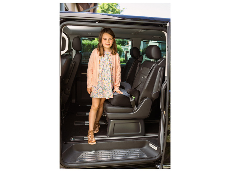 Une fille monte dans un Volkswagen noir avec un siège enfant.
