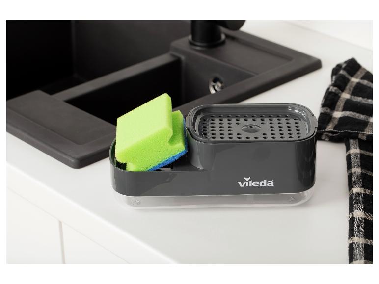 Support gris pour brosse et éponge à vaisselle avec éponge verte près de l'évier de cuisine
