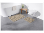 Tapis de bain beiges sur un sol en carrelage gris.