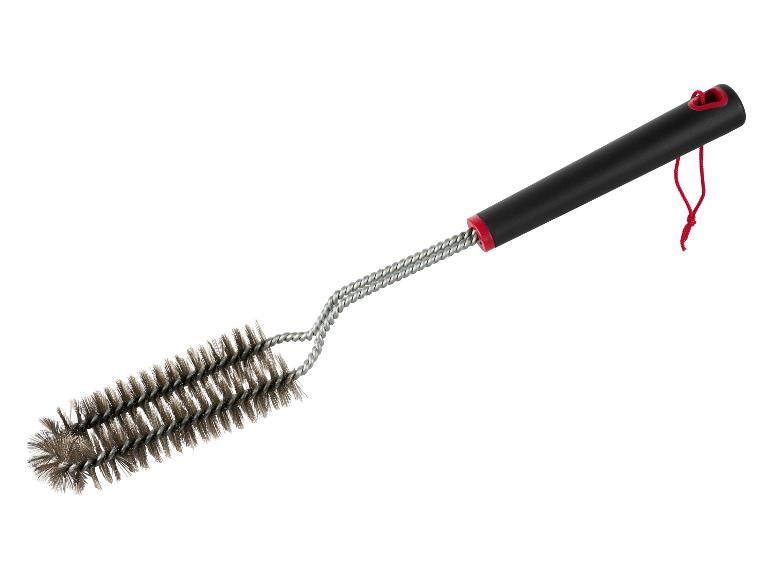 Une brosse à barbecue avec une poignée noire et une boucle rouge.