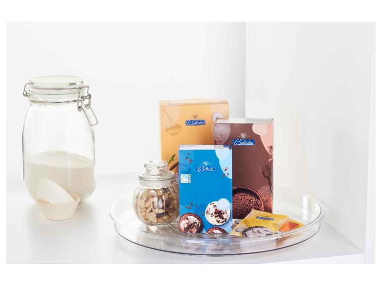 Accessoires de pâtisserie, y compris des mélanges à pâtisserie Belbake, des noix et des moules à cupcakes sur un plateau tournant.