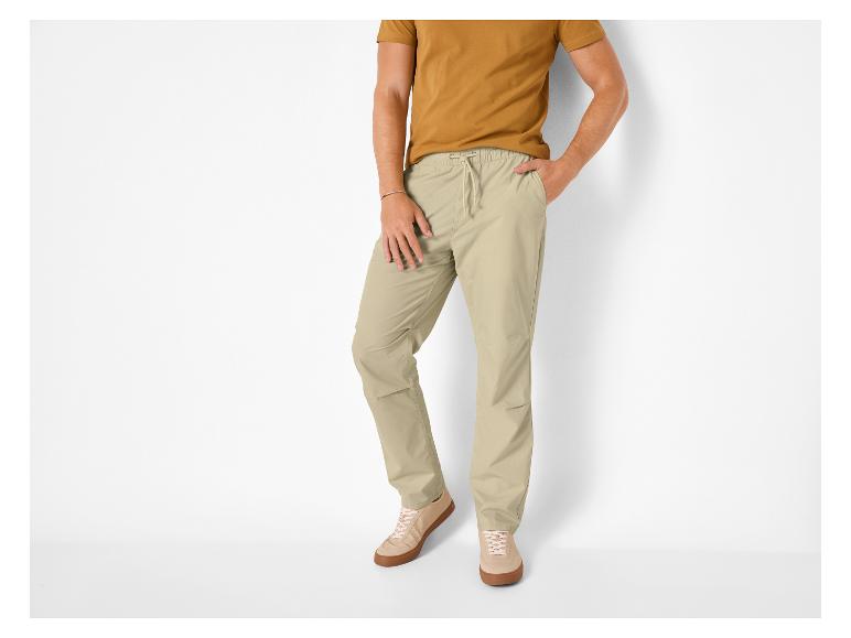 Homme en t-shirt jaune moutarde et pantalon beige à cordon, baskets beiges.