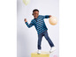 Un garçon portant un t-shirt rayé et un jean joue avec des ballons.