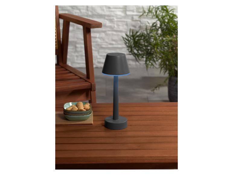 Une lampe de table noire avec un éclairage bleu sur une table en bois.
