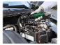 Main utilisant une clé à cliquet pneumatique pour débrancher une batterie de voiture.