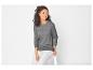 Une femme portant un pull gris et un pantalon blanc.