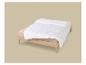 Couette blanche sur un matelas avec des draps beiges sur un lit en bois.
