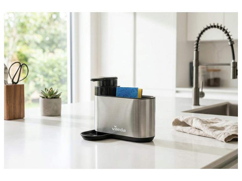 Distributeur de savon et porte-éponge en acier inoxydable à côté de l'évier de cuisine.