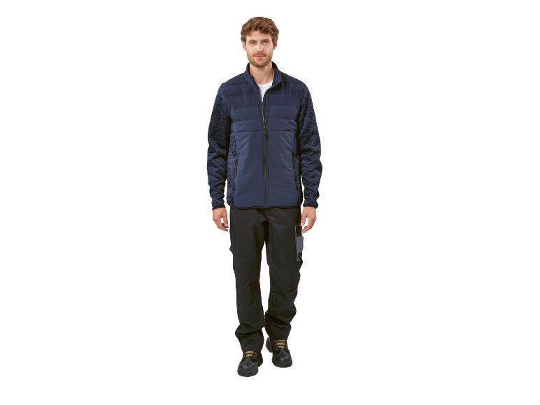 Un homme porte une veste bleu foncé avec un pantalon bleu foncé avec des poches de travail.