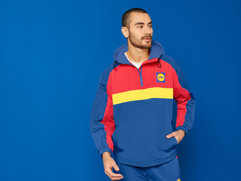 Un homme portant une veste de survêtement bleue avec le logo Lidl.