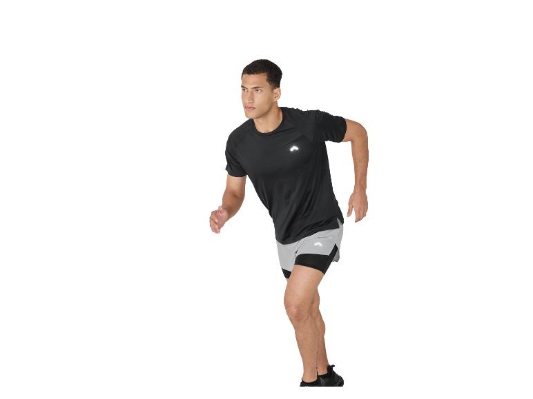 Homme en t-shirt de sport noir et short gris courant sur fond blanc.