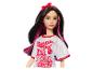 Poupée Barbie avec des mèches roses et un t-shirt rouge qui dit 'Twist Up the Volume'.