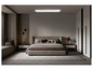 Une chambre à coucher moderne avec un grand lit, deux tables de chevet et un grand miroir.