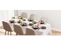 Table à manger dressée avec des bols à soupe, des assiettes de salade et des verres pour six personnes.