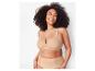 Une femme présente un soutien-gorge Elomi Cate beige à armatures et des culottes taille haute.