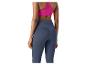 Femme en leggings bleu foncé et soutien-gorge de sport rose, vue de dos.