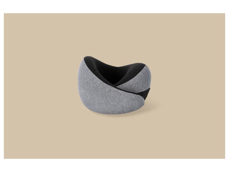Oreiller de voyage ergonomique gris et noir sur fond beige.
