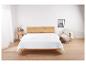 Une couette blanche sur un lit en bois dans une chambre.